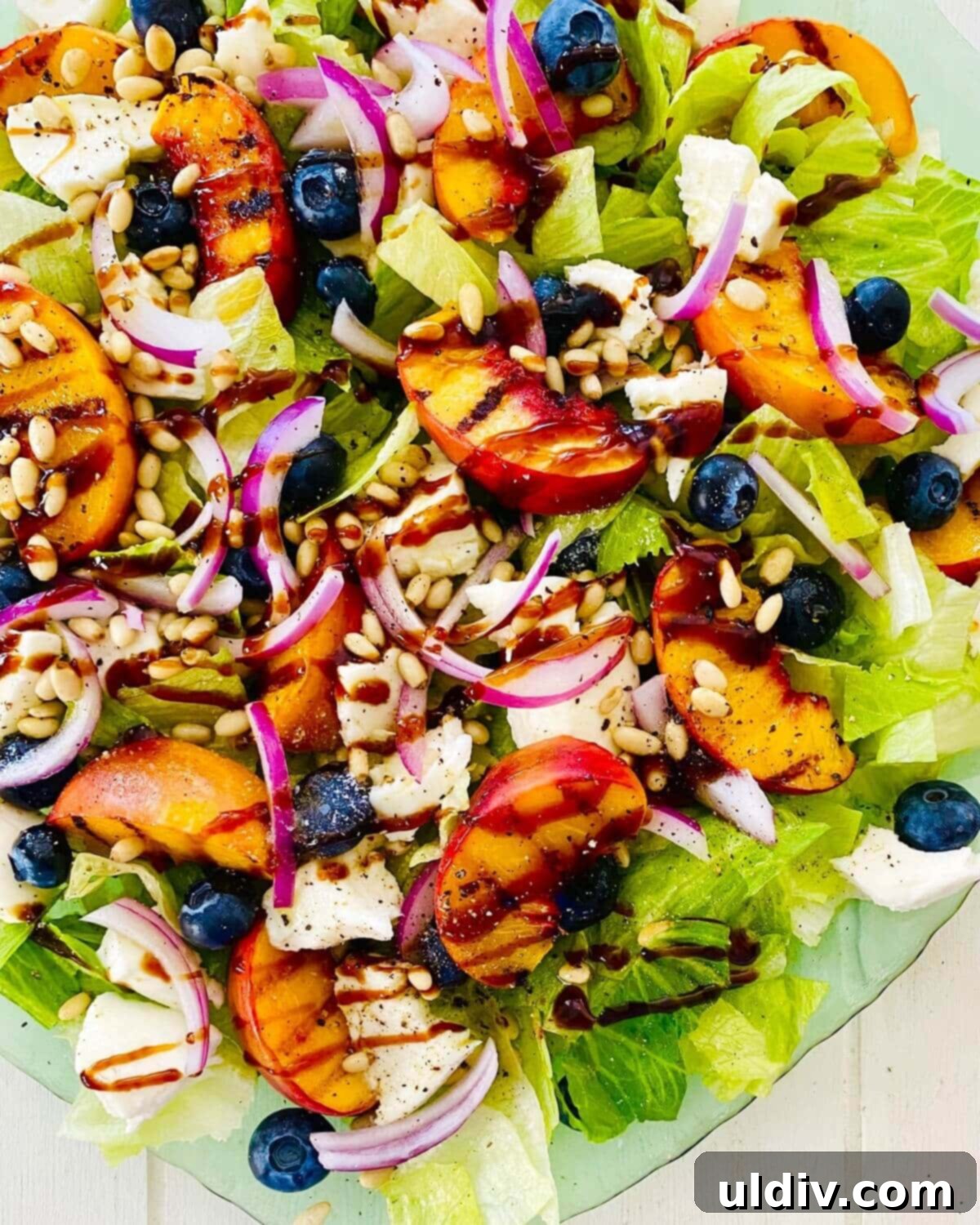 Golden Grille Peach & Creamy Mozzarella Salad 2 Grilled peach salad with mozzarella and blueberries on a rustic platter, garnished with fresh herbs.