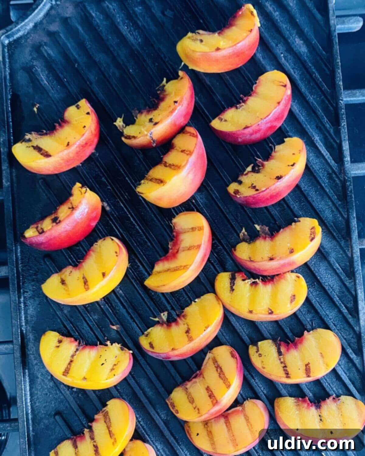 Golden Grille Peach & Creamy Mozzarella Salad 4 Grilling peach wedges on a cast iron grill pan, showing distinct char marks.