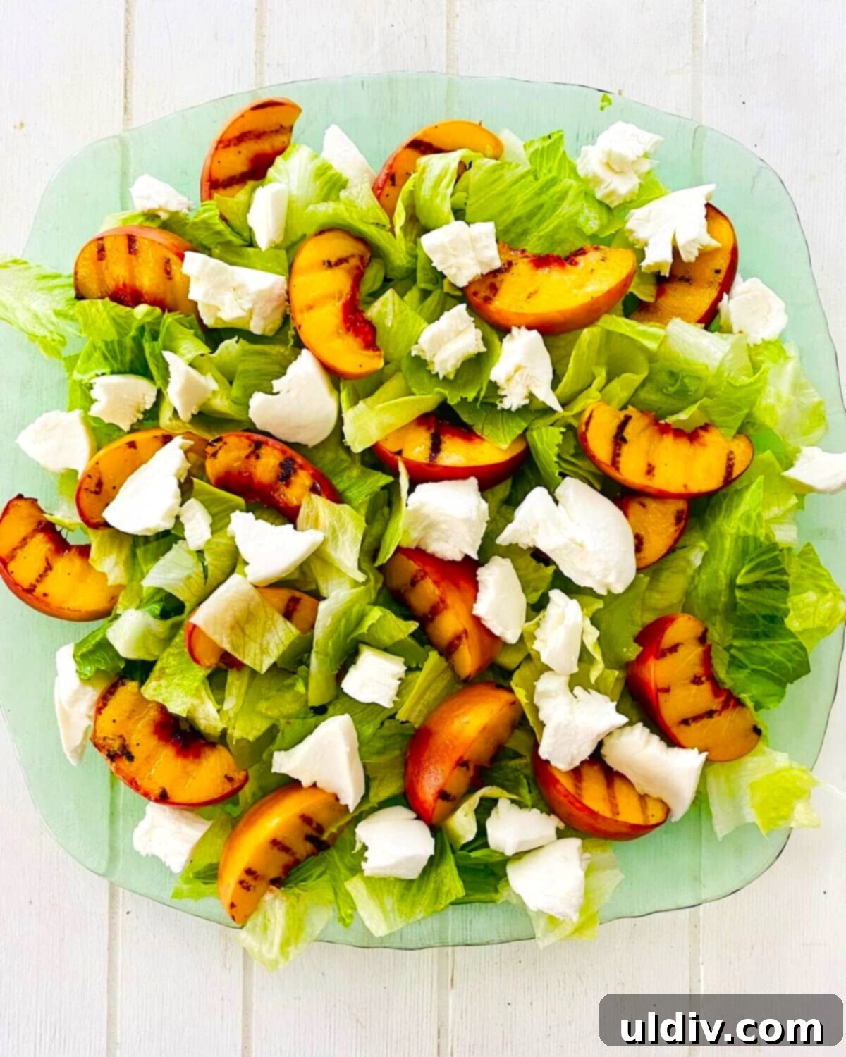Sweet and Savory Grilled Peach Mozzarella Salad 5 A platter with lettuce, grilled peaches and fresh mozzarella.