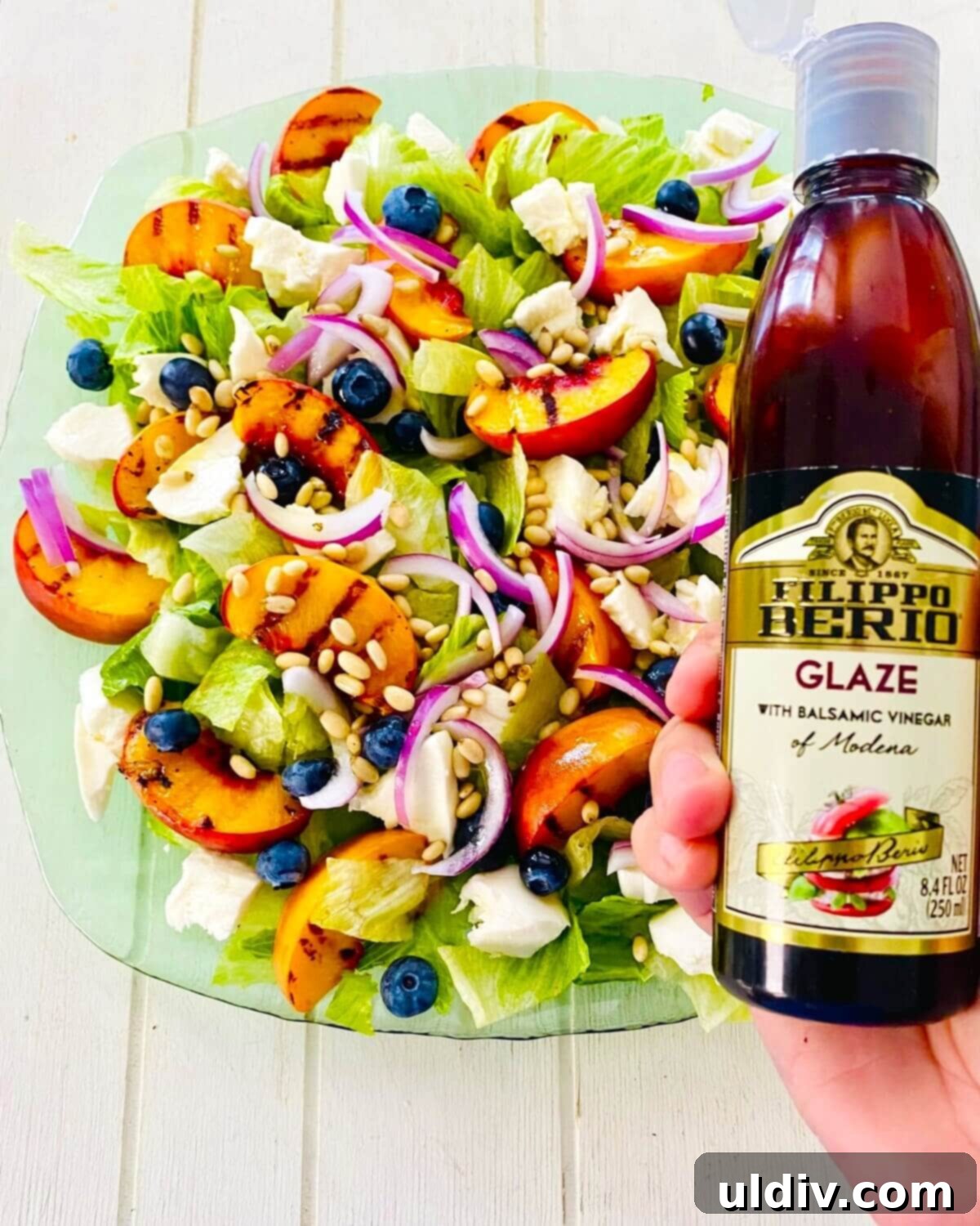 Golden Grille Peach & Creamy Mozzarella Salad 8 A hand drizzling thick balsamic glaze over the grilled peach salad.