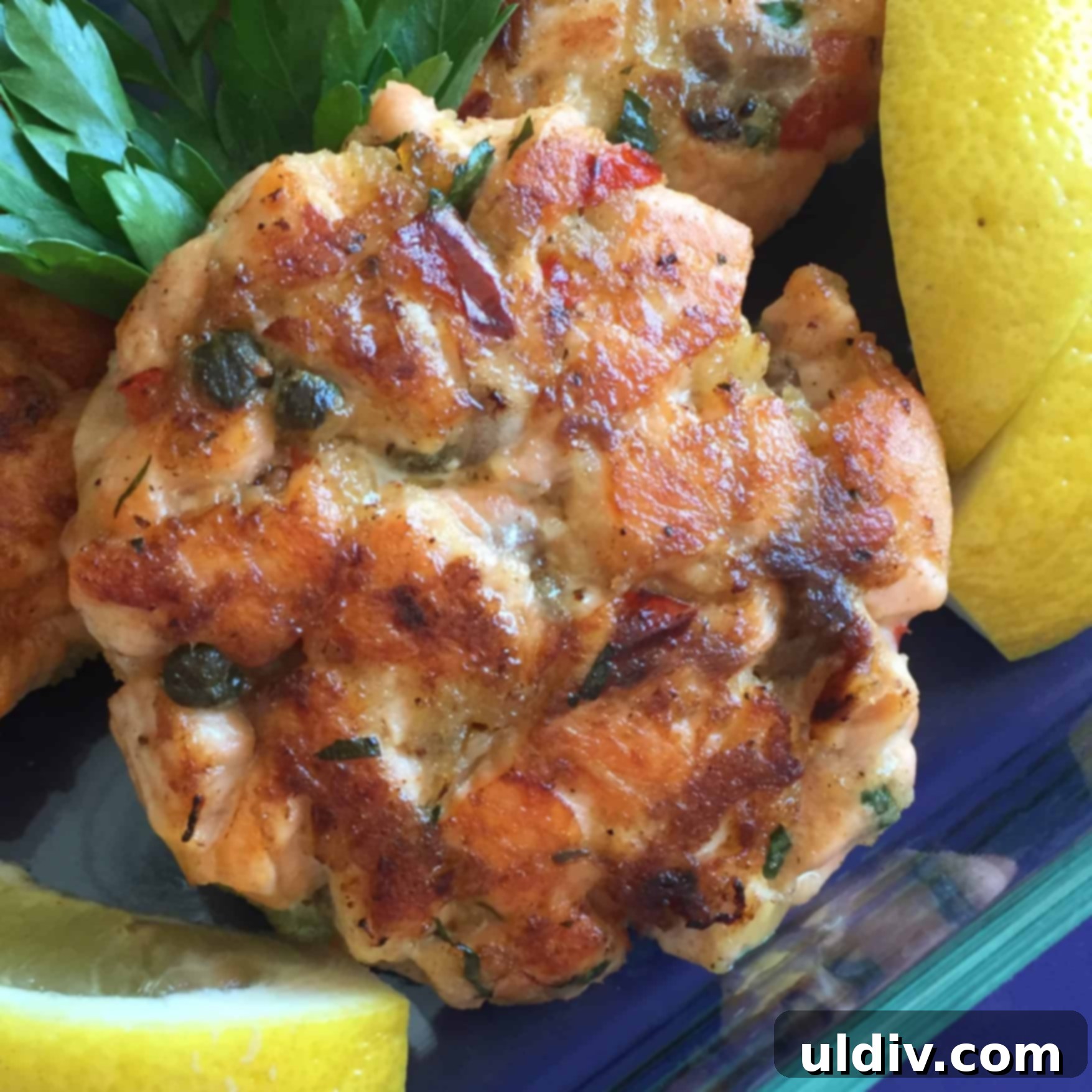 a fresh salmon cake with lemon wedges.