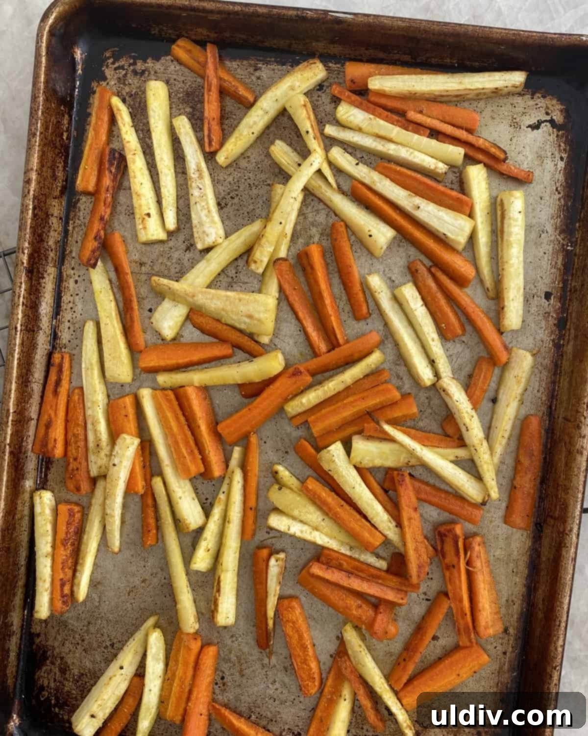 Crispy Oven-Baked Carrot and Parsnip Sticks 4 A sheet pan filled with various vegetables roasting in a hot oven