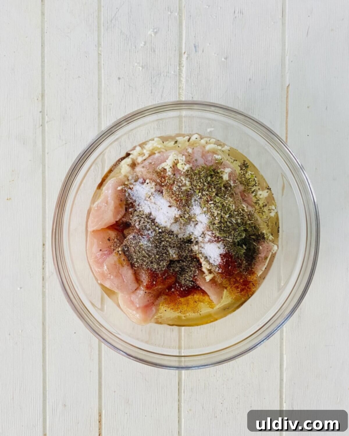 Herb-Roasted Italian Chicken with Creamy Caesar Dip 5 Raw chicken pieces in a bowl with marinade ingredients.