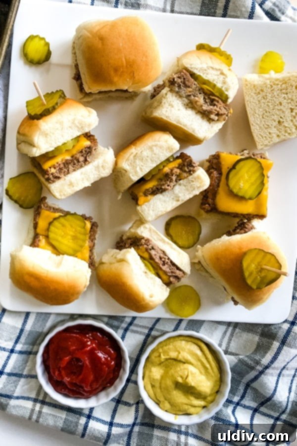 Crowd-Pleasing Cheeseburger Sliders 19 A plate featuring 8 perfectly assembled cheeseburger sliders, each garnished with a dill pickle chip.