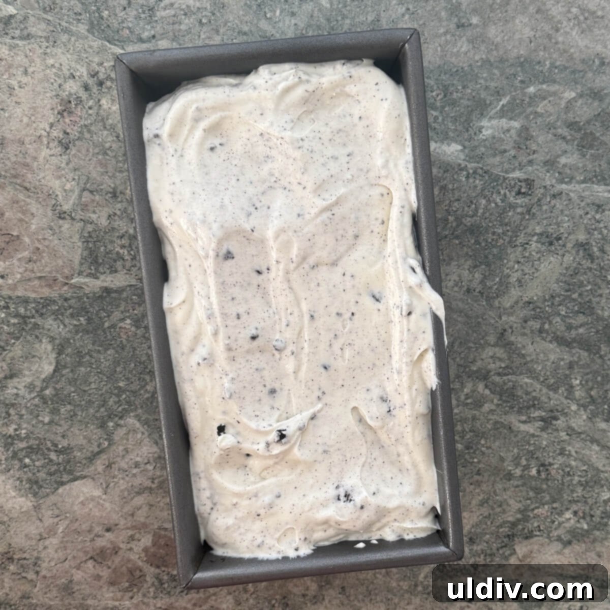 Ice cream mixture smoothed into a chilled loaf pan, ready for freezing.