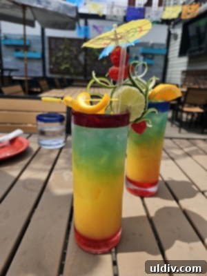 Chicago's Tatas Tacos: An Unmissable Flavor Journey 4 Vibrant Paradise mocktails at Tatas Tacos, featuring layers of fruit and syrups.