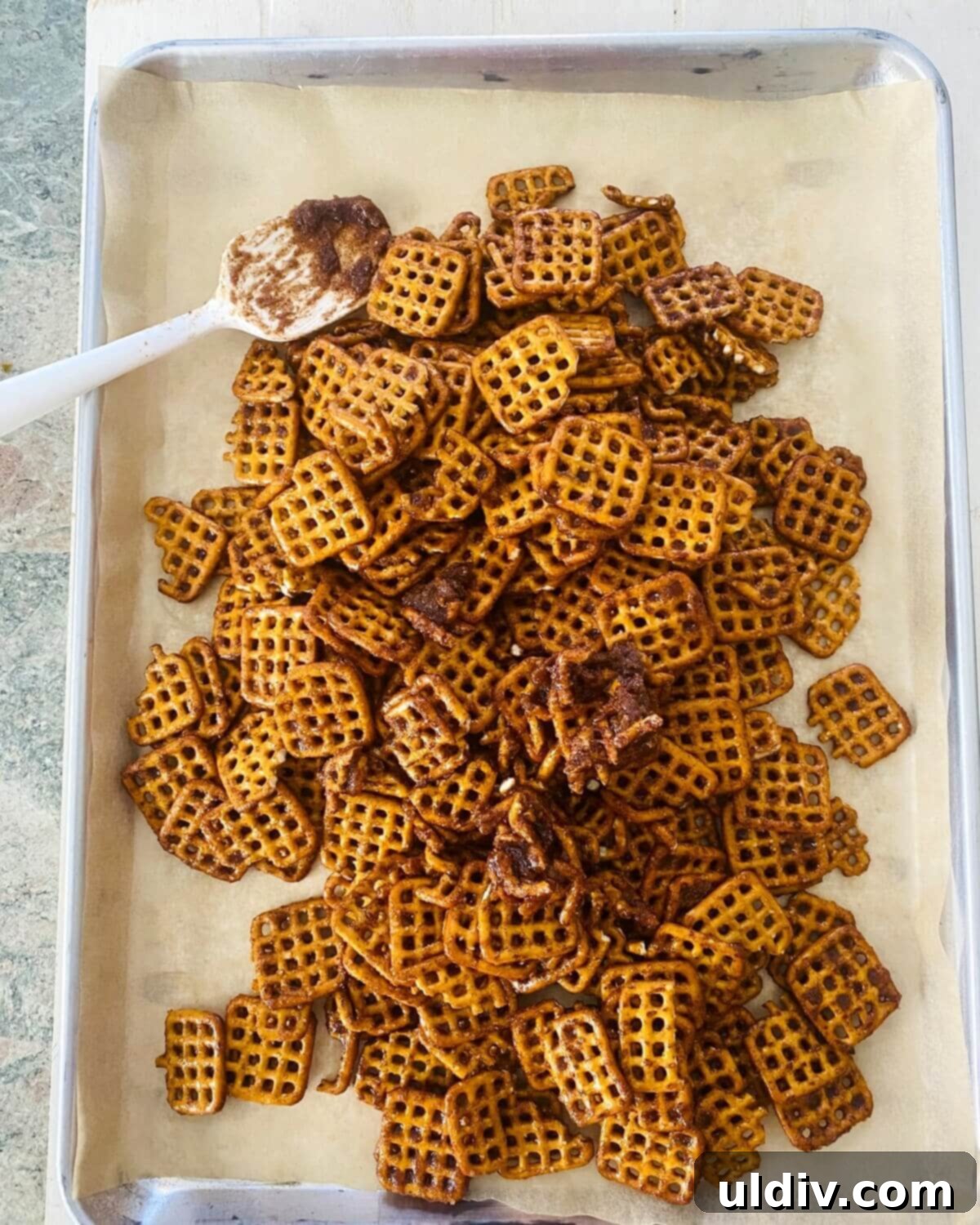 Creamy Pumpkin Pretzel Twists 7 Pumpkin spiced pretzels spread in a single layer on a parchment-lined baking sheet.