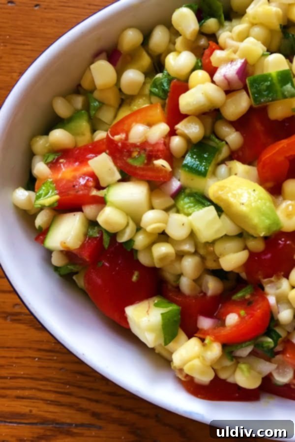 A Colorful Summer Medley of Avocado, Corn, Cucumber, and Tomato 2 Vibrant summer salad featuring fresh corn, creamy avocado, ripe tomatoes, and crisp cucumbers, dressed with a light vinaigrette.