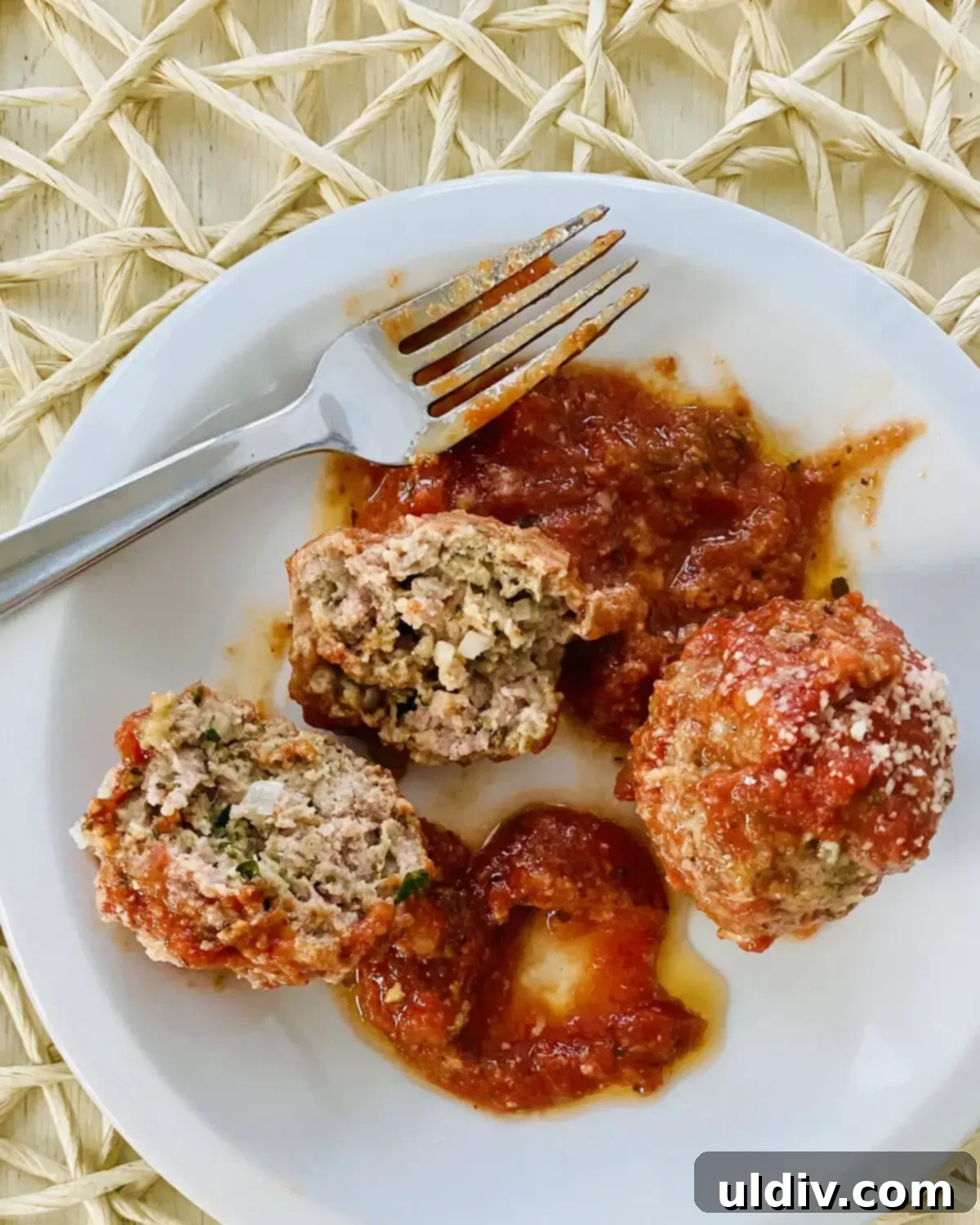 Oven-Kissed Meatballs in Rich Marinara 3 Two plump, saucy meatballs resting on a white plate, ready to be enjoyed.