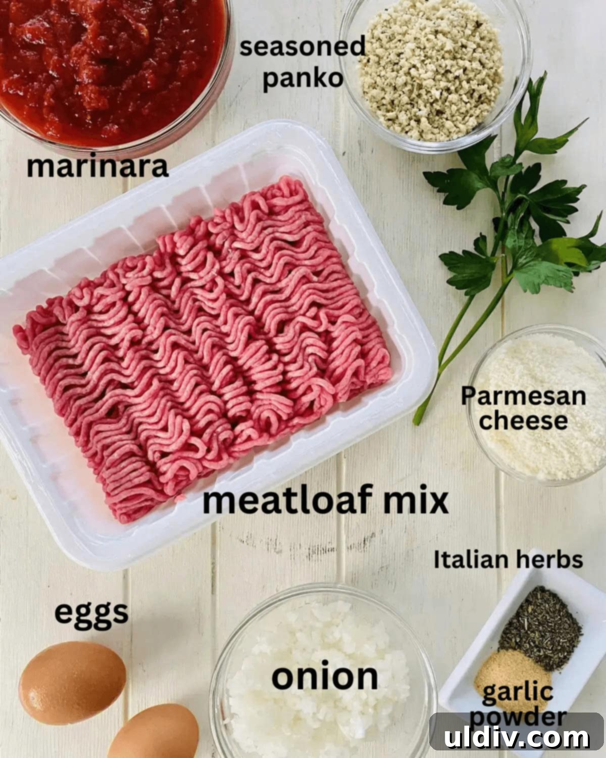 Oven-Kissed Meatballs in Rich Marinara 4 A flat lay of ingredients for meatballs and marinara, including ground meat, onion, panko, Parmesan, sauce, parsley, eggs, Italian spices, and garlic powder.
