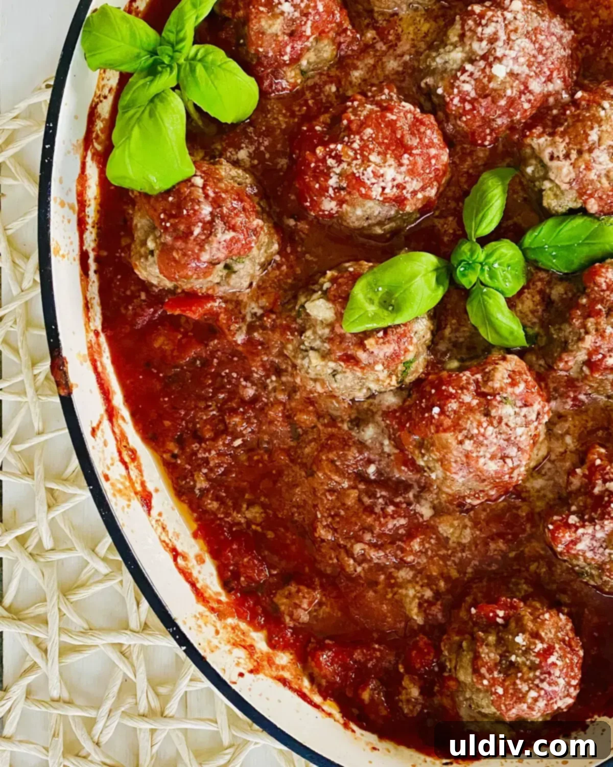 Oven-Kissed Meatballs in Rich Marinara 8 Freshly baked Italian meatballs, bubbling in a vibrant red sauce, garnished with fresh herbs and more cheese.