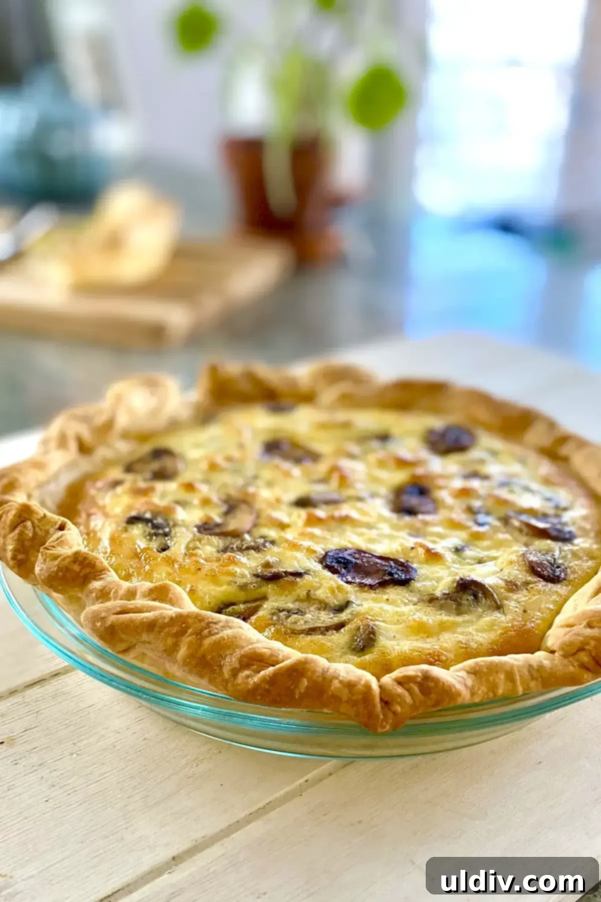 Golden Flaky Mushroom Quiche 11 a whole mushroom quiche on a white board.