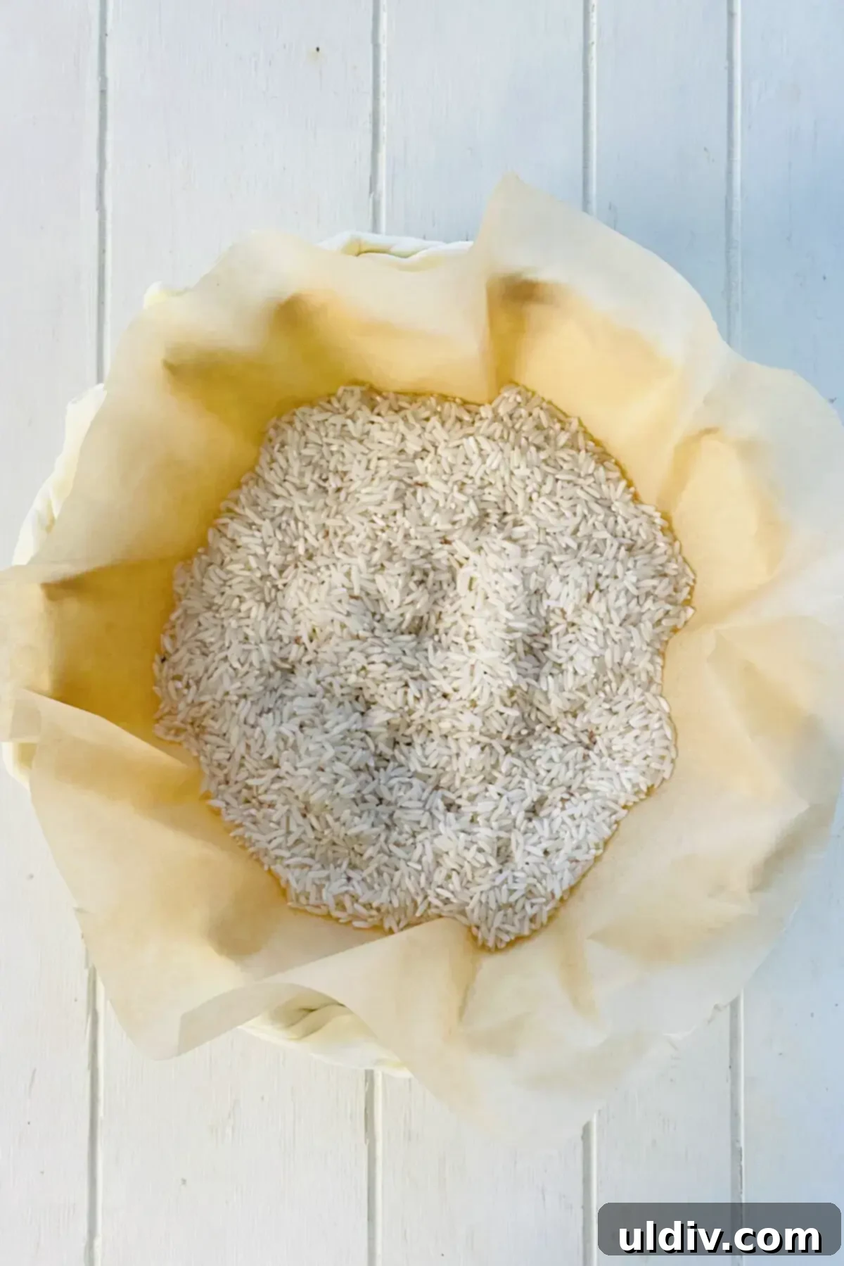 Golden Flaky Mushroom Quiche 5 lining crust with parchment paper and uncooked rice to parbake.