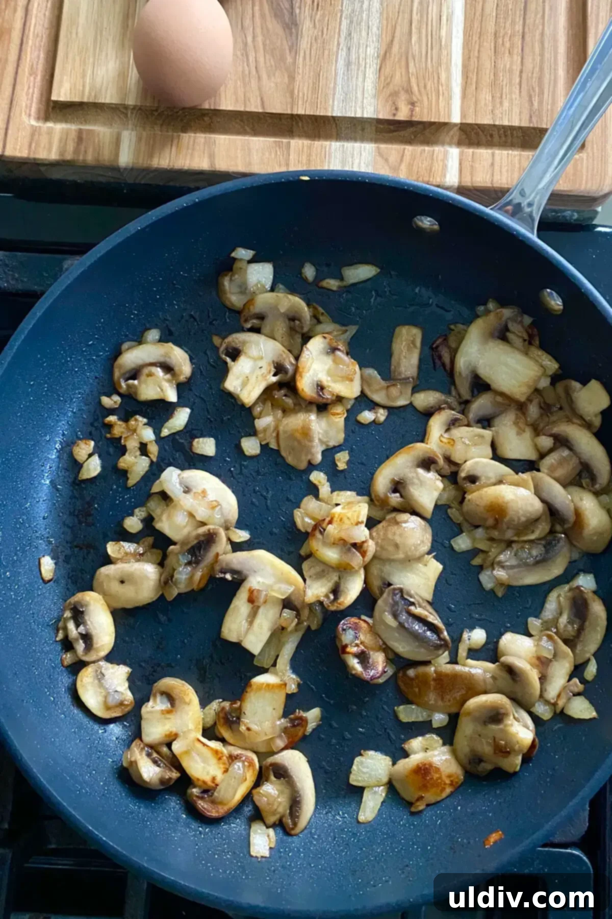 Flaky Puff Pastry Mushroom Quiche 7 Sizzling sautéed mushrooms and onions browning in a large pan, releasing their savory aroma.