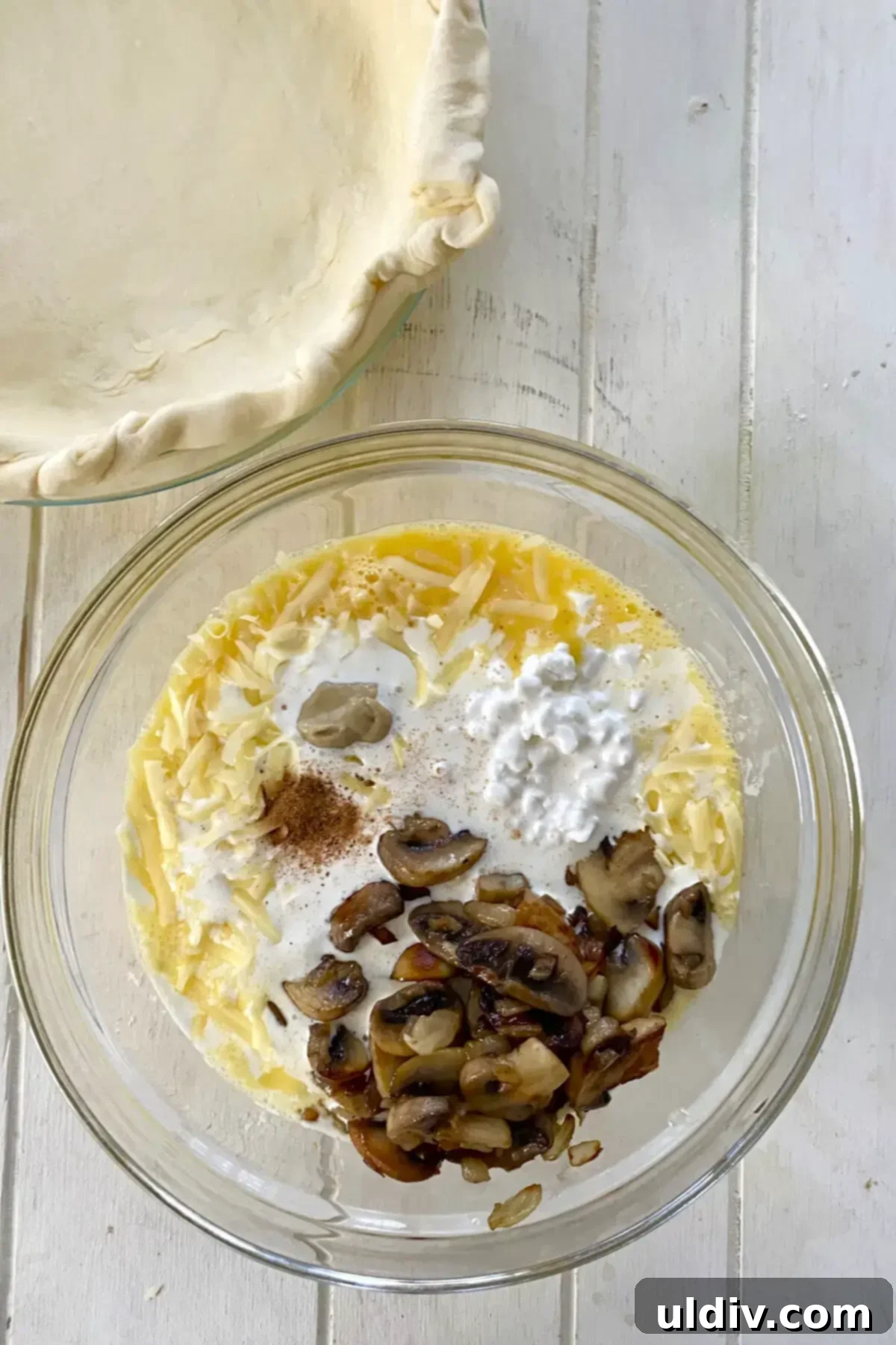 Golden Flaky Mushroom Quiche 8 glass bowl with beaten eggs, cottage cheese, heavy cream, cheese, mustard, nutmeg, salt and pepper.