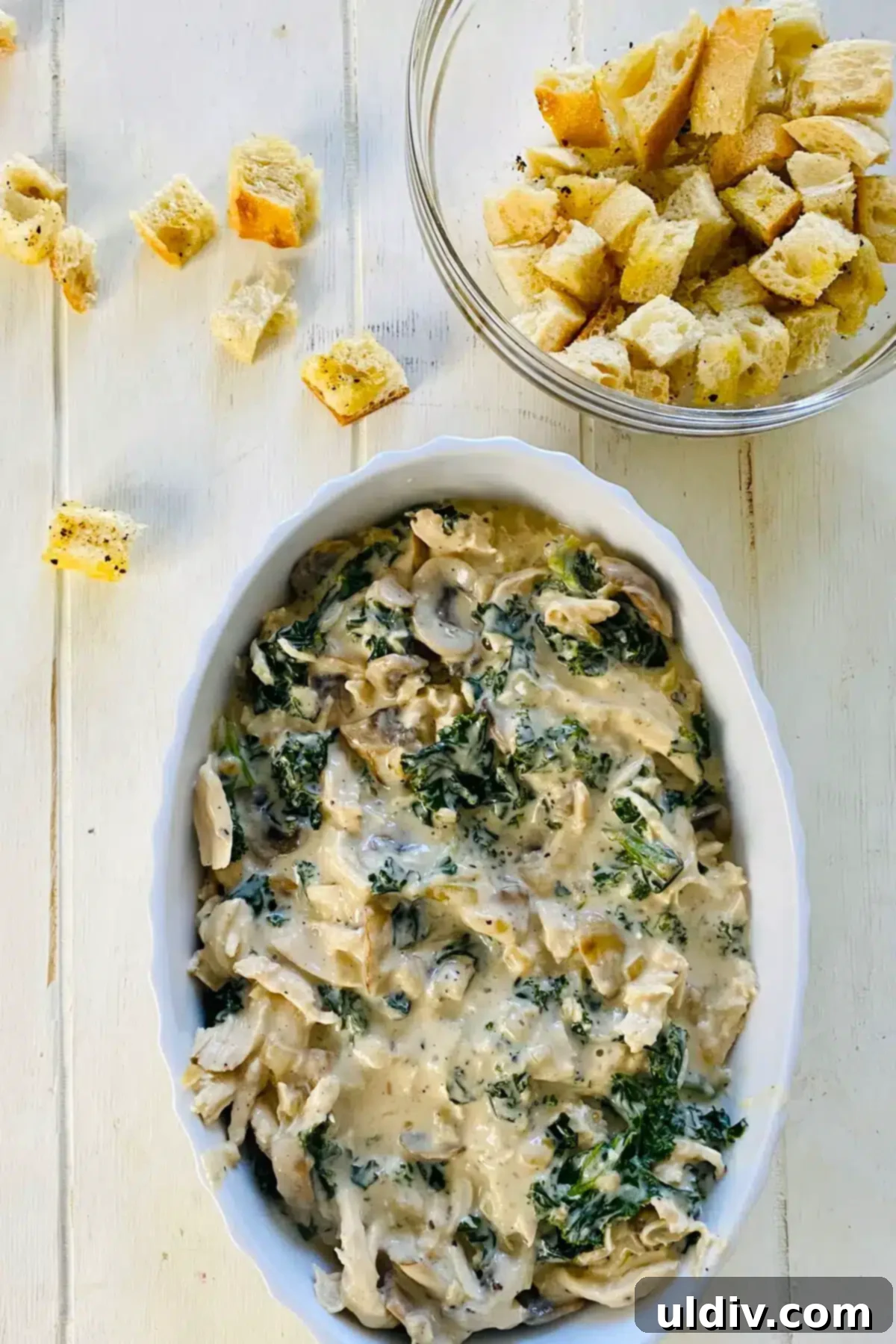 Comforting Creamy Chicken and Kale Casserole 11 The chicken and kale casserole mixture transferred into a baking dish, awaiting its crispy topping.