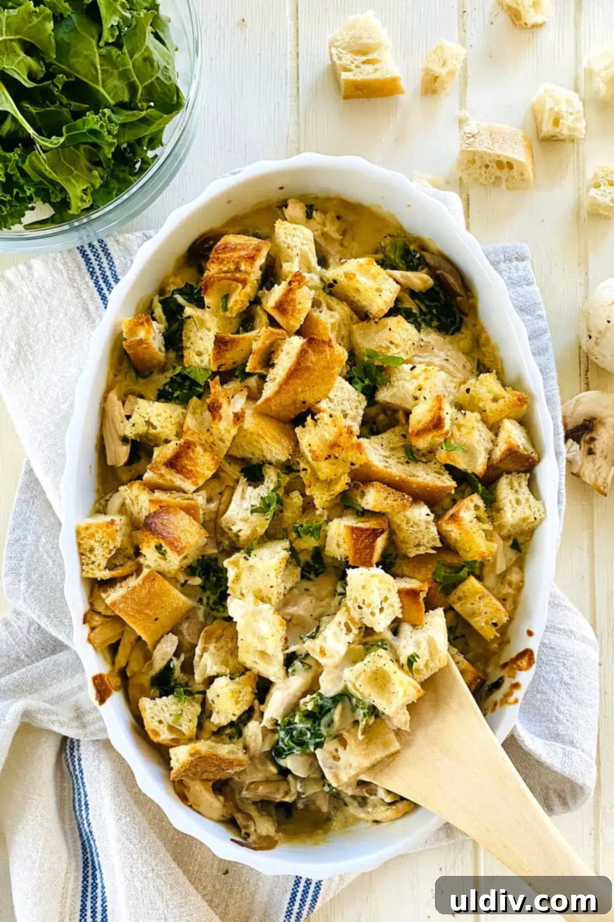 Comforting Creamy Chicken and Kale Casserole 3 Creamy Chicken and Kale Casserole with a wooden spoon, ready to be served.