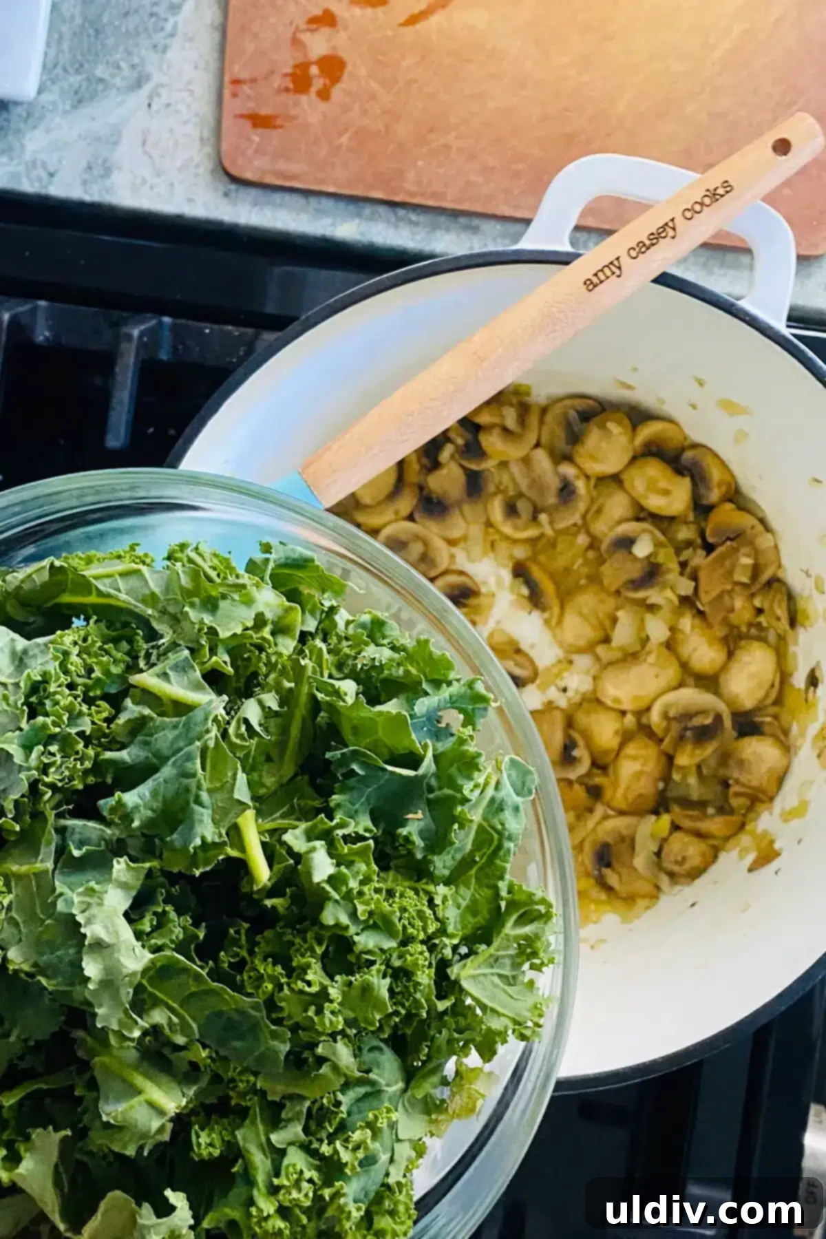 Hearty Creamy Chicken and Kale Bake 6 Fresh chopped kale being added to the sautéed mushrooms and onions in a Dutch oven.