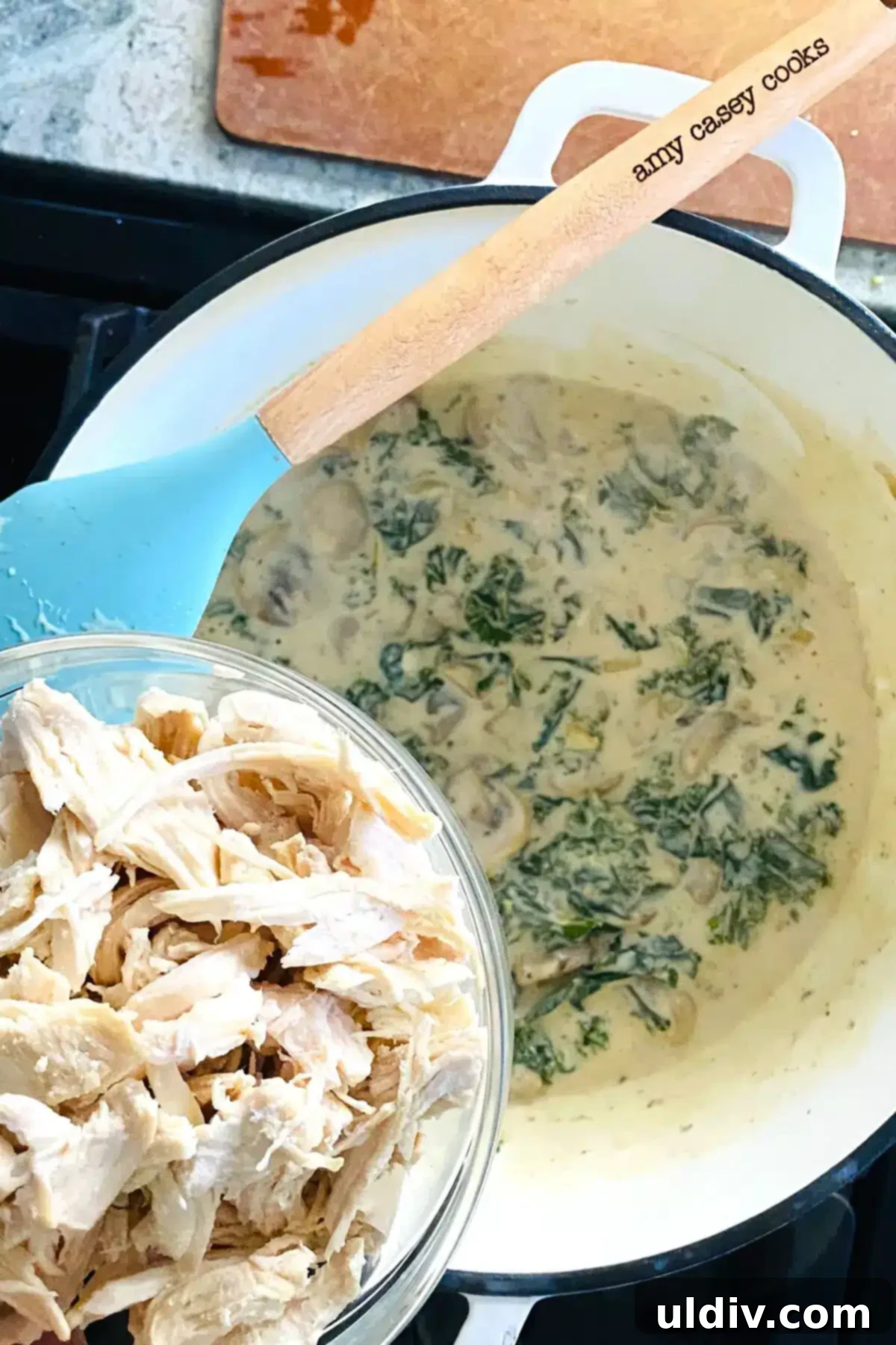 Comforting Creamy Chicken and Kale Casserole 10 Shredded chicken being added to the rich kale cream sauce, ready to be warmed through.