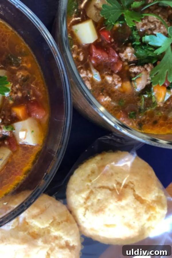 Homestyle Hamburger Potato Soup 3 Two steaming bowls of hearty hamburger soup, served alongside golden cornbread muffins, inviting a warm and comforting meal.