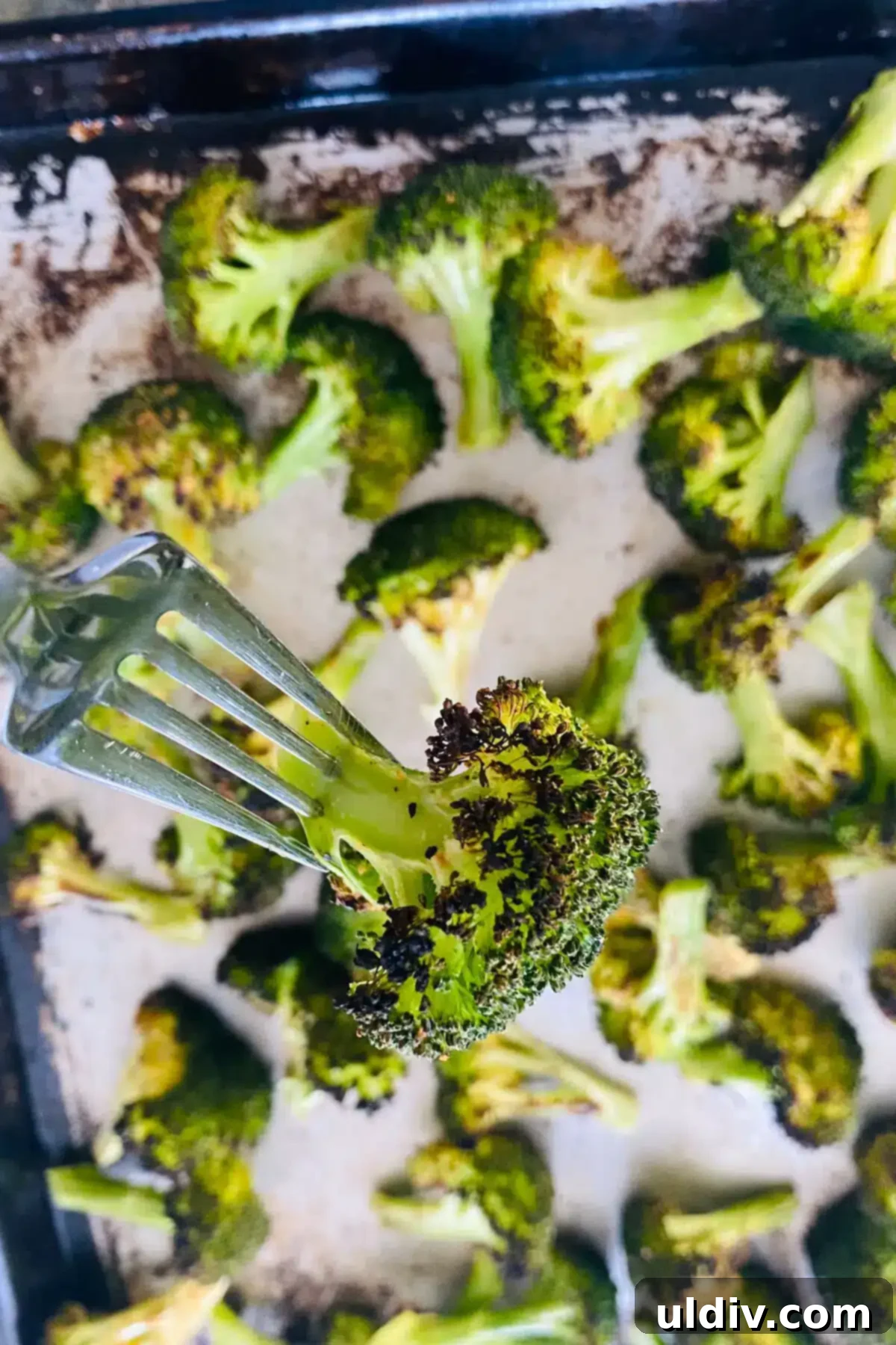 Golden Garlic Crispy Broccoli 11 broiled broccoli on a fork.
