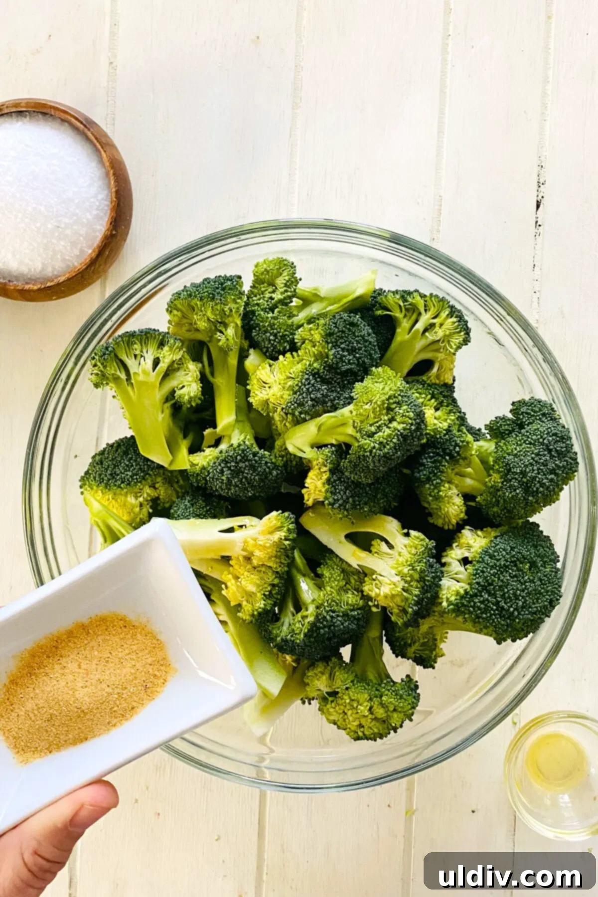 Golden Garlic Crispy Broccoli 6 adding garlic powder to raw broccoli.
