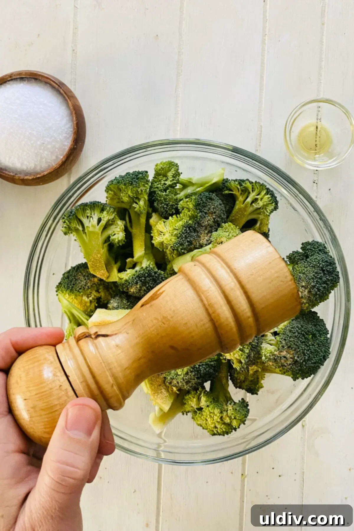 Golden Garlic Roasted Broccoli 7 A peppermill grinding fresh black pepper over raw broccoli.