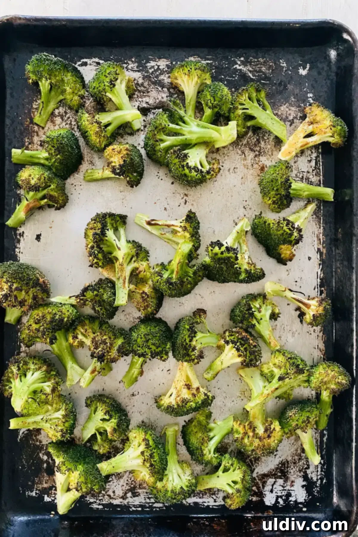 Golden Garlic Roasted Broccoli 10 Broiled broccoli, golden and charred in spots, on a sheet pan just out of the oven.
