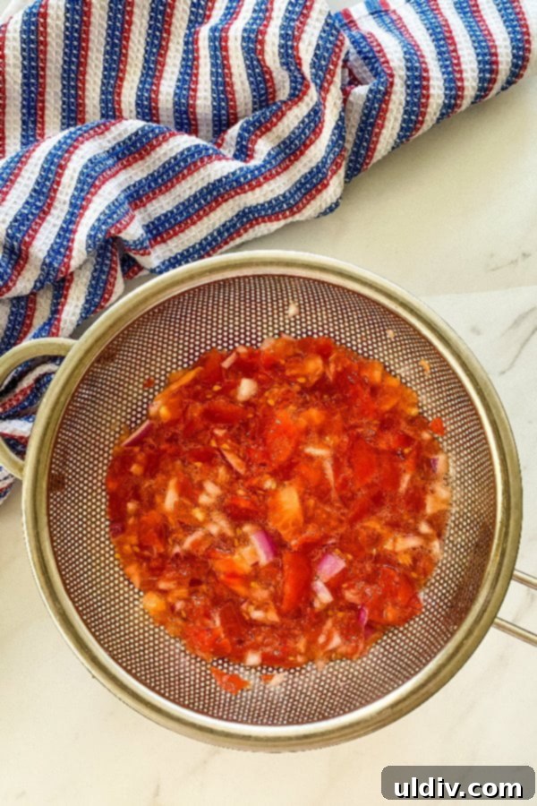 Garden Fresh Tomato Relish Burgers 6 Chopped tomatoes and red onions in a strainer, draining excess liquid to prepare for relish.