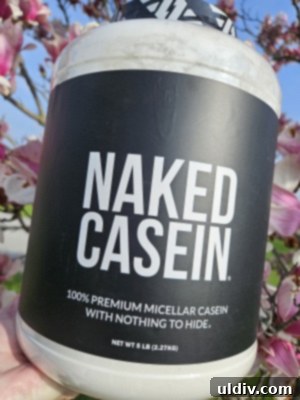 Naked Nutrition Casein Honest Review 3 A person holding a scoop of Naked Nutrition Micellar Casein Protein Powder, ready for mixing.