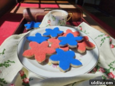 Patriotic Memorial Day Cookies 4 A beautifully arranged plate of Ann Clark forget-me-not sugar cookies, alongside a teacup, evoking a cozy and reflective Memorial Day afternoon.