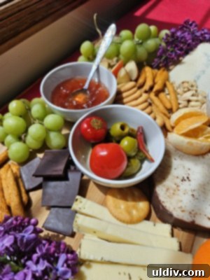 Savoring Cheese Month: Storage Secrets Revealed 7 An elaborate summer grazing board laden with artisan cheeses, fresh fruit, crackers, and savory snacks.