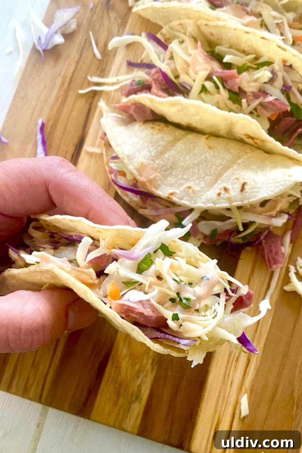 Irish Tacos: The Corned Beef & Cabbage Twist 3 A hand holding an Irish taco, highlighting its generous filling and vibrant colors.