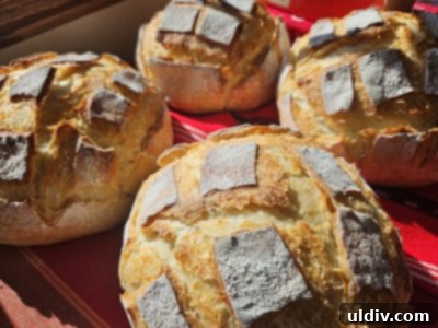 Fresh Flour: Milled in Your Kitchen 4 A perfectly baked, rustic loaf of bread, possibly made with freshly milled flour, resting on a wooden cutting board.