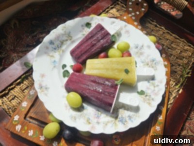 Summer 2025: Savoring Summers Past 4 A hand holding a vibrant green grape popsicle, ready to be enjoyed.
