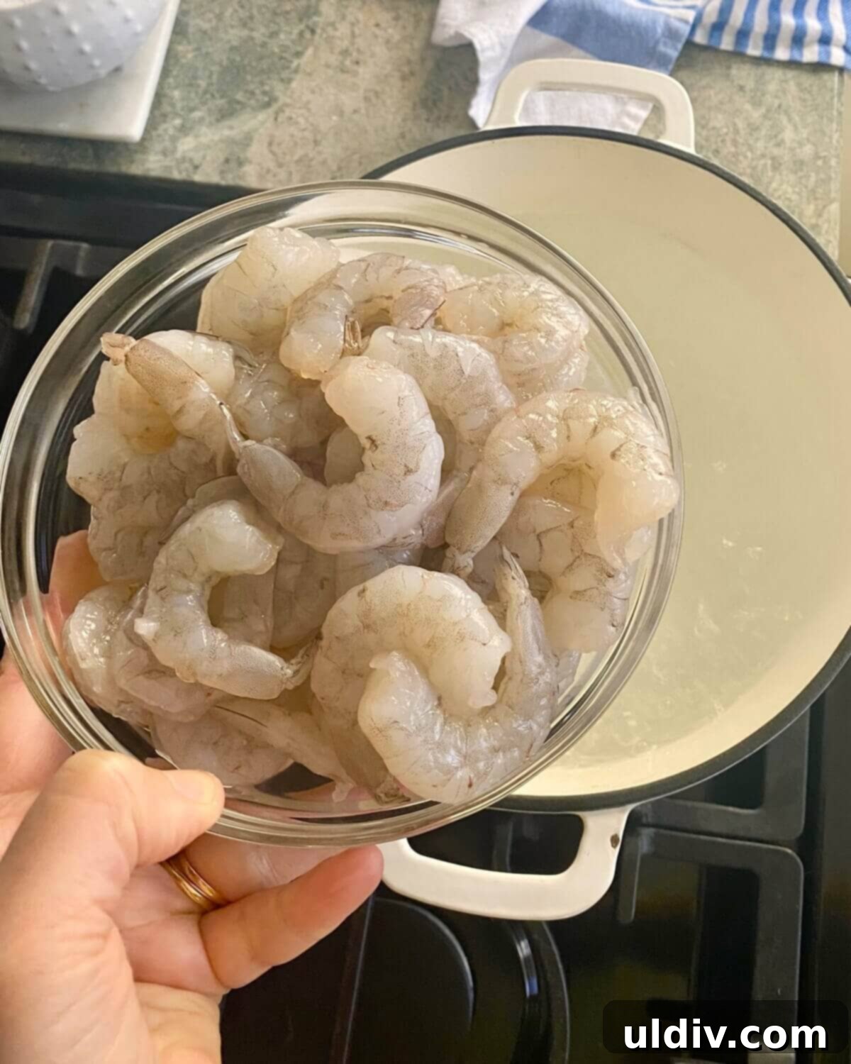 Effortless Old Bay Shrimp Salad 6 Raw shrimp being added to a pot of boiling water for cooking.