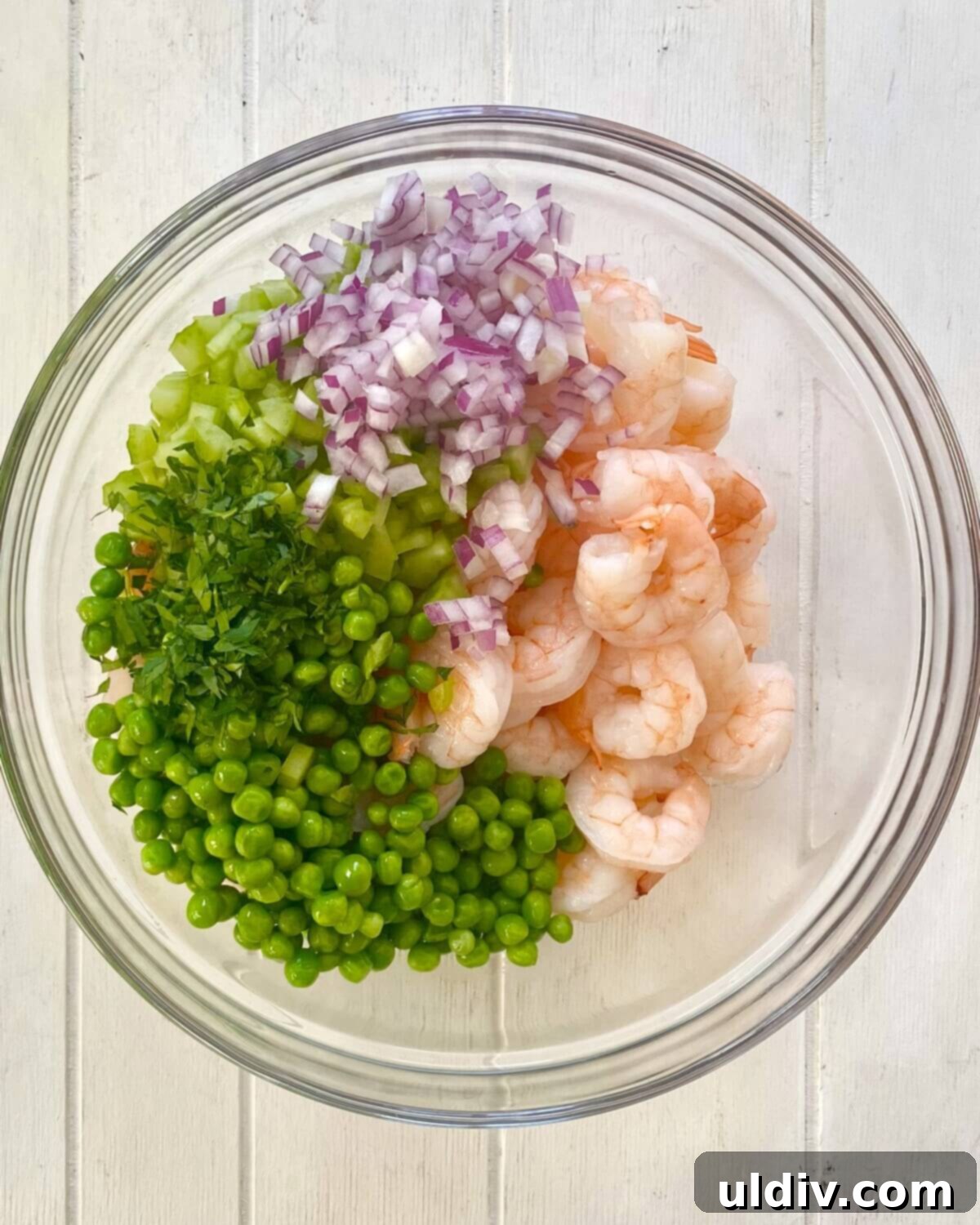 Quick Old Bay Shrimp Salad Sensation 10 cooked shrimp, chopped celery, red onions and parsley in a glass bowl.