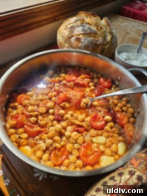 Confit Tandoori Chickpeas: A Fusion of Flavors 7 A beautifully plated serving of Confit Tandoori Chickpeas, accompanied by slices of fresh sourdough bread and a dollop of Greek yogurt dressing, ready to be enjoyed.