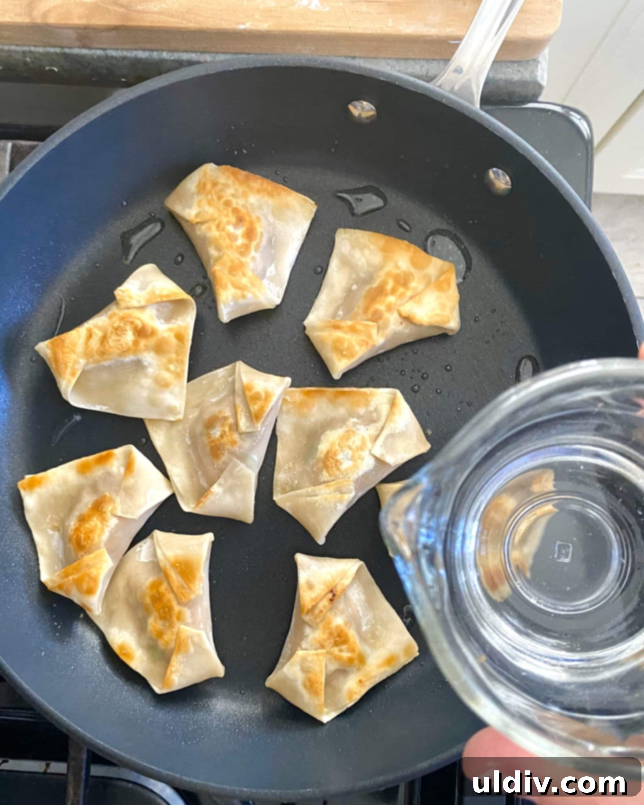 Irresistible Pork Potstickers with Signature Dipping Sauce 11 Adding water to pan with potstickers.