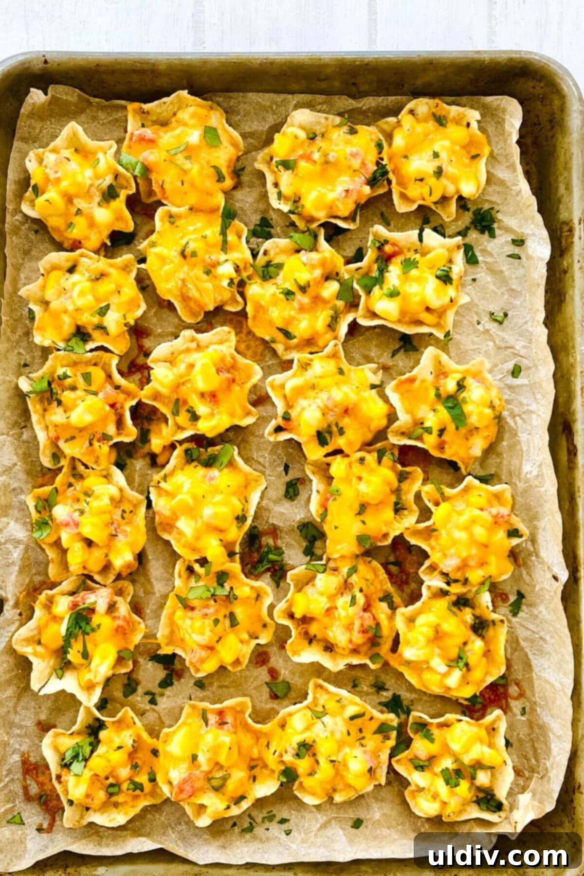 Baked Cheesy Corn Delight 11 a sheet pan with Tostito Scoops with corn dip with cream cheese.