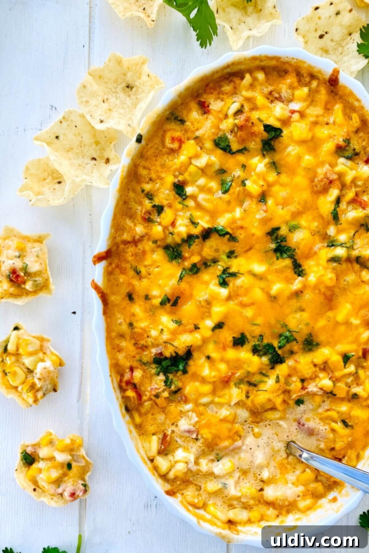 Baked Cheesy Corn Delight 10 hot dip with a spoon in it.