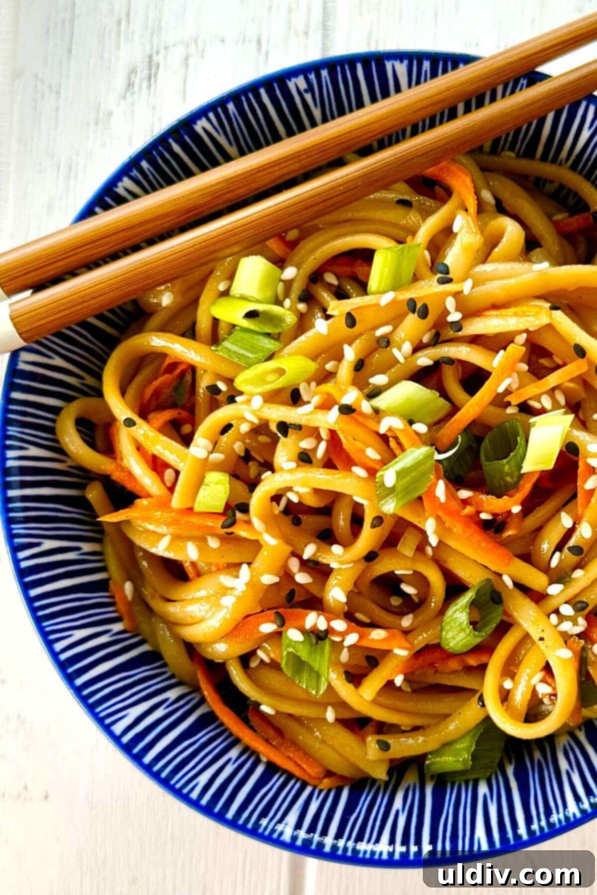 Effortless One-Pot Garlic Sesame Noodles 2 A vibrant bowl of garlic sesame noodles, garnished with fresh green onions and sesame seeds.