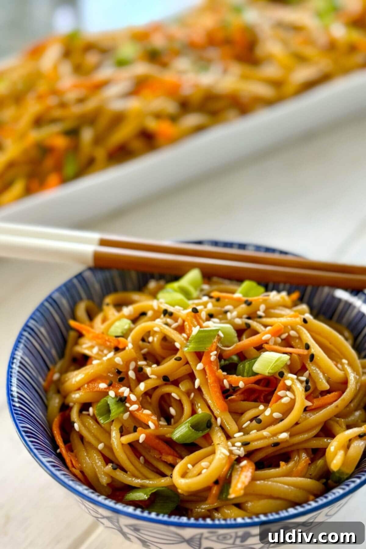 Effortless One-Pot Garlic Sesame Noodles 3 A serving dish and a single bowl of garlic sesame noodles, ready to be enjoyed.
