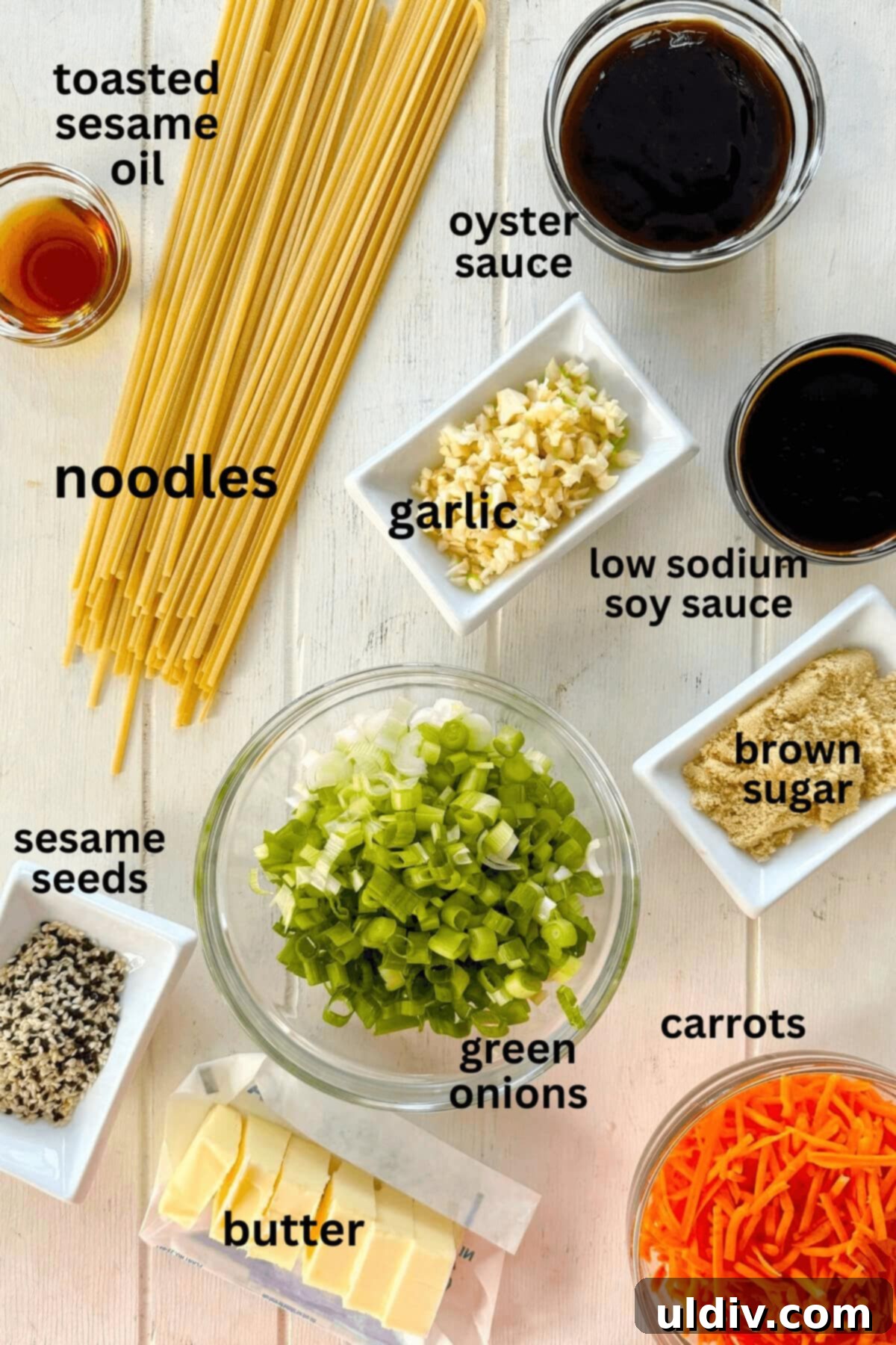 Effortless One-Pot Garlic Sesame Noodles 4 An array of ingredients laid out: noodles, sesame oil, brown sugar, green onions, soy sauce, sesame seeds, garlic, oyster sauce, and butter.