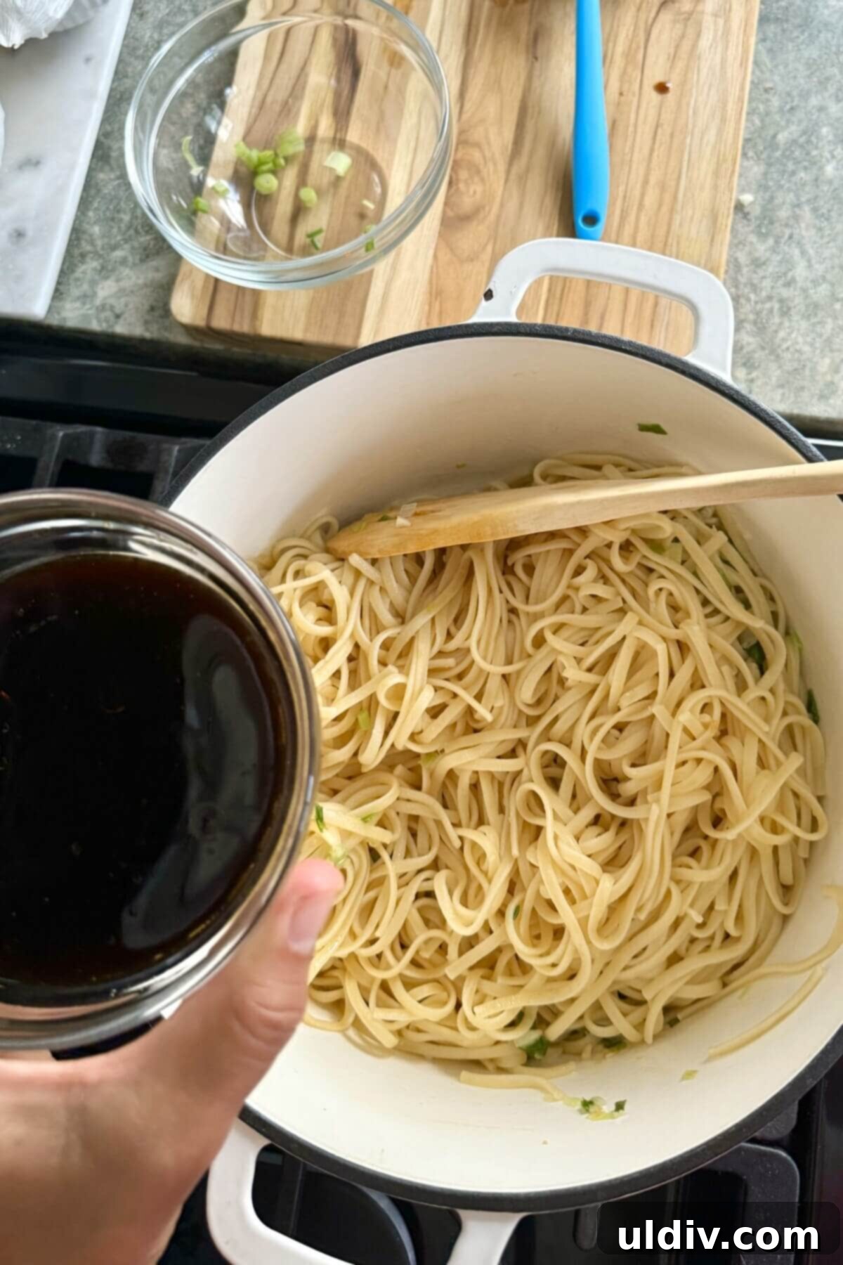 Effortless One-Pot Garlic Sesame Noodles 8 Cooked noodles and sauce being added to the pan with sautéed aromatics.