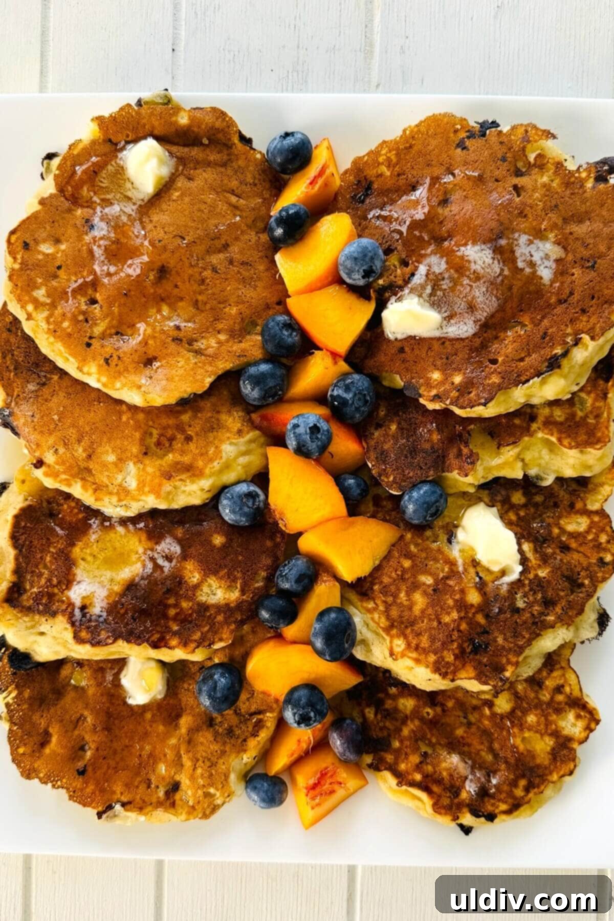 Power-Packed Banana Cottage Cheese Protein Pancakes 12 A serving platter with warm cottage cheese protein pancakes and a colorful array of fresh cut fruit.