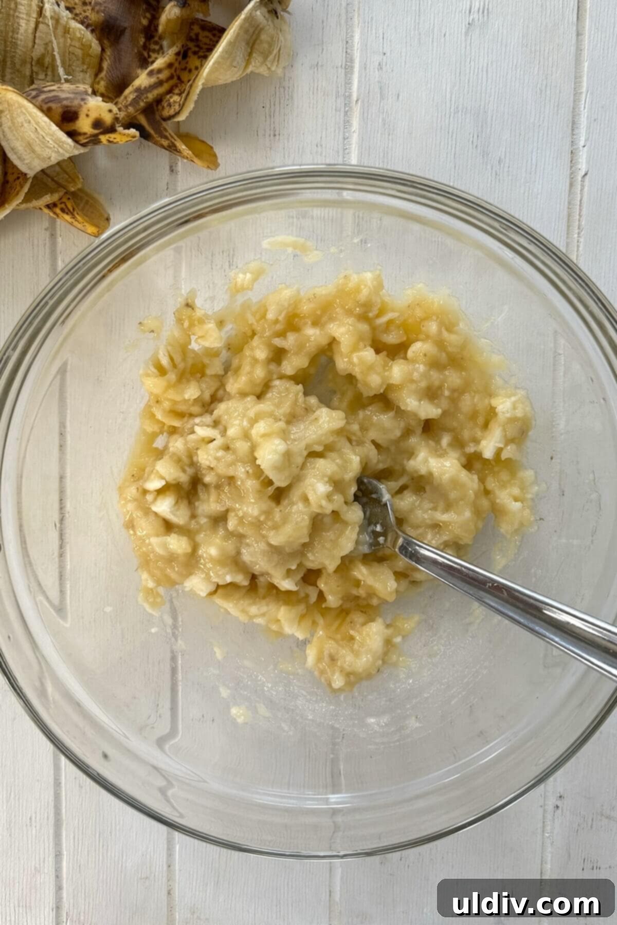 Power-Packed Banana Cottage Cheese Protein Pancakes 5 Mashed ripe bananas in a glass bowl, ready for pancake batter preparation.