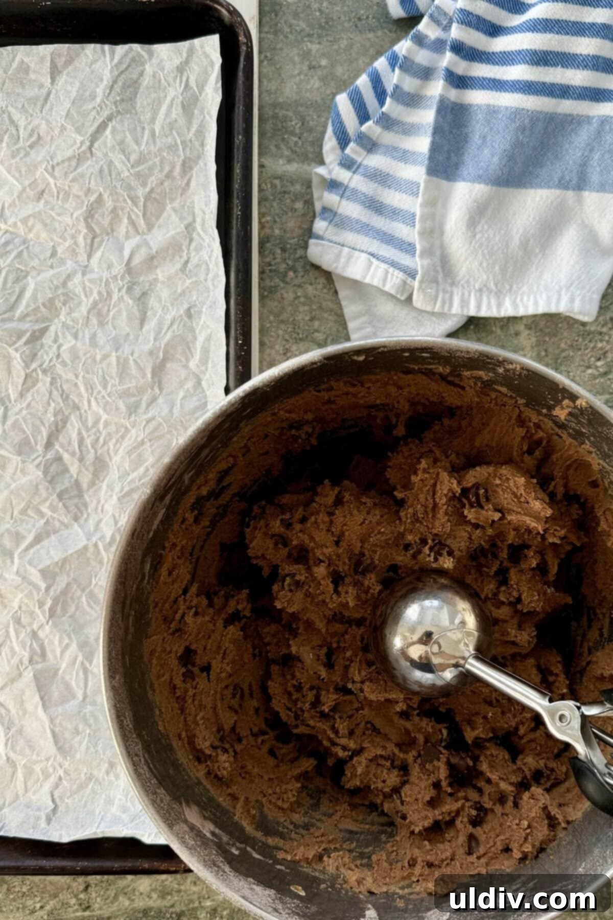Double Chocolate Pudding Cookies 9 A large cookie scoop with chocolate cookie dough, ready to be placed on a baking sheet.
