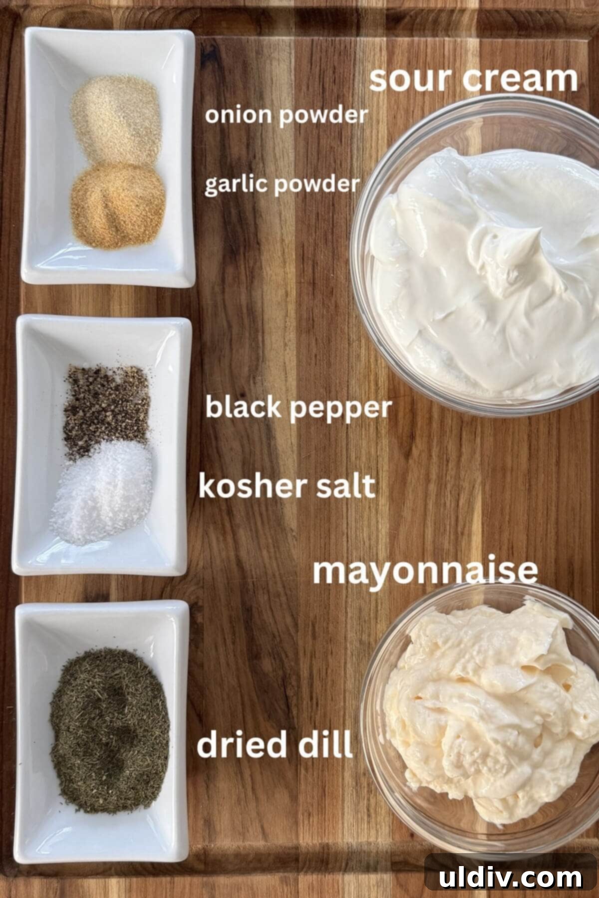 Fresh Dill Dip in Minutes 4 A flat lay photograph of all the dill dip ingredients: garlic powder, onion powder, black pepper, kosher salt, dried dill, sour cream, and mayonnaise, neatly arranged for clarity.
