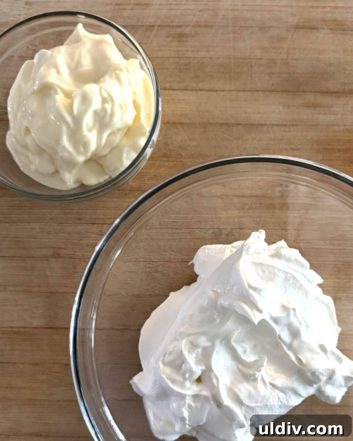 Easy 5-Minute Dill Dip 5 A bowl filled with creamy mayonnaise alongside a separate bowl of tangy sour cream, ready for mixing to create a rich base for the dill dip.